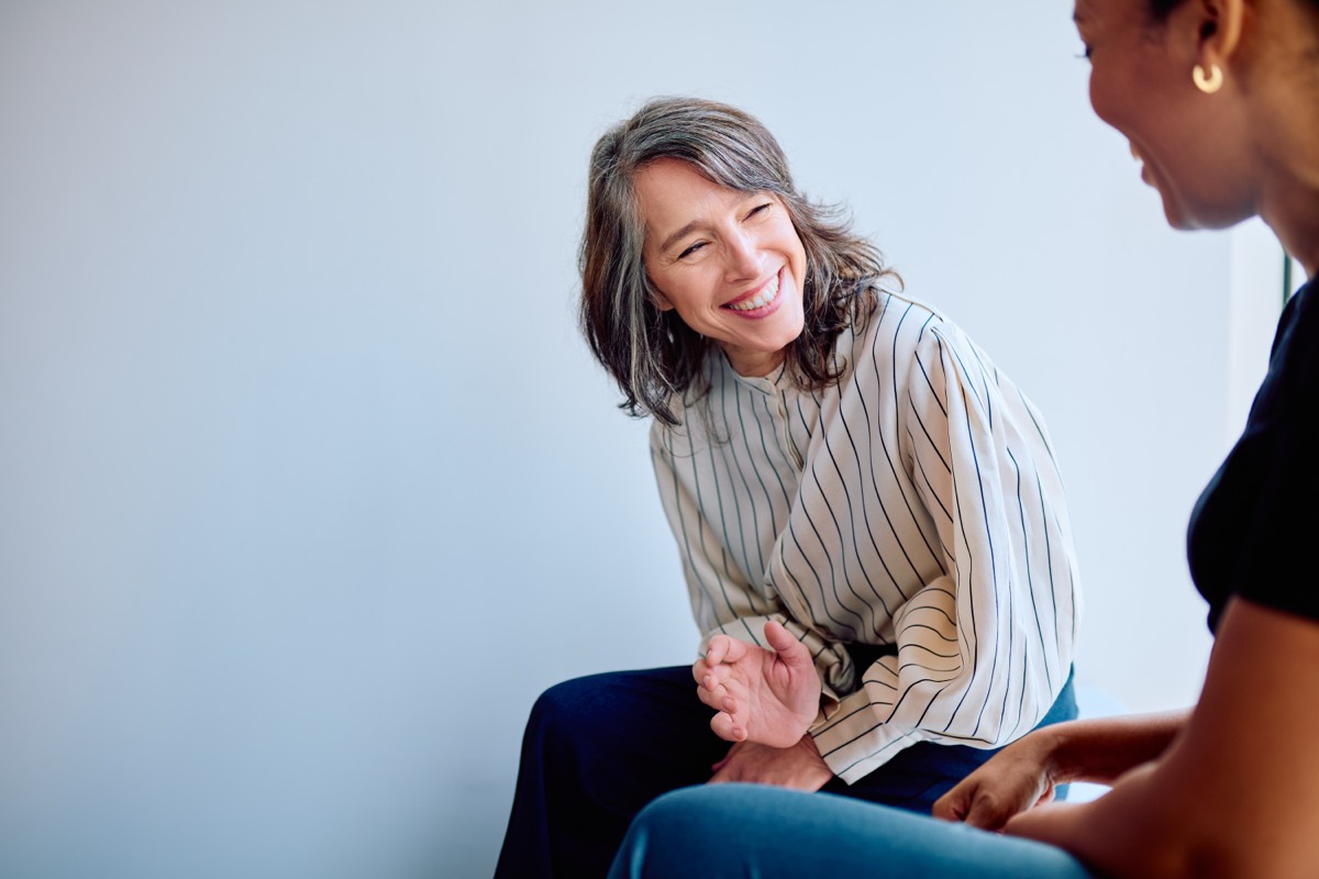 Two colleagues share a warm, supportive conversation